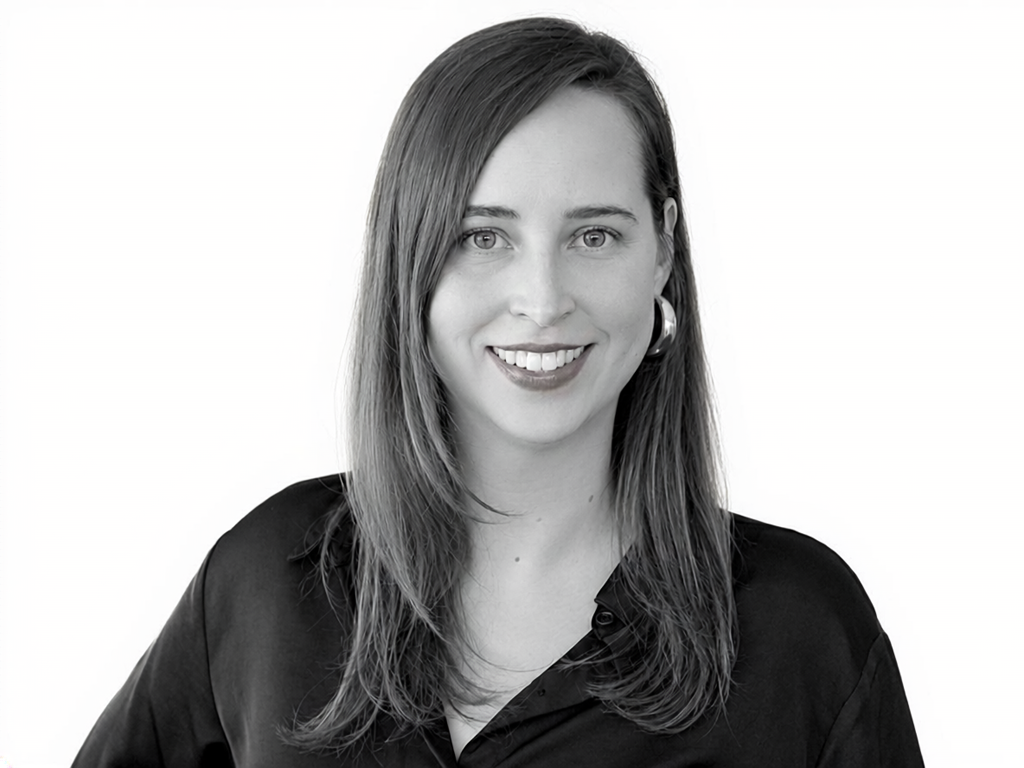 Head-and-shoulders portrait of a smiling woman with shoulder-length hair, wearing a black blouse.